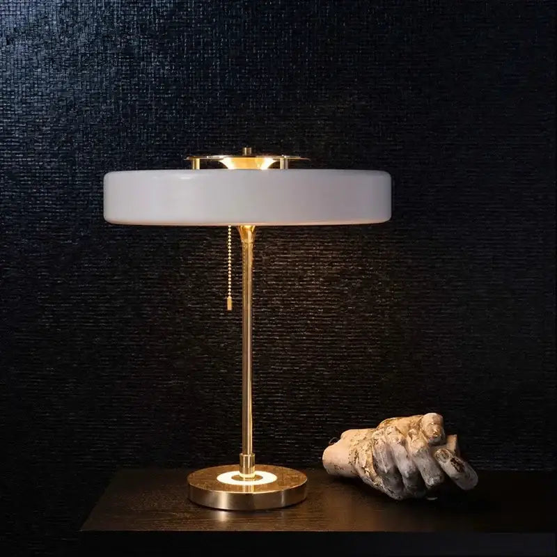 A sleek modern table lamp with frosted white glass shade and polished brass base for decorbites scandinavia lighting