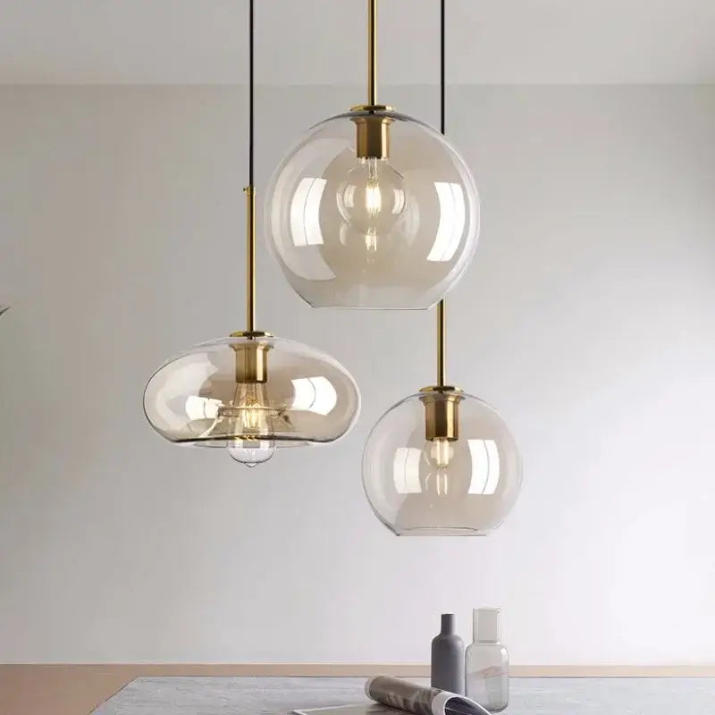 Three modern glass pendant lights with brass accents and iron finish cord pendant installation for dining room