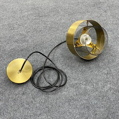 Modern brass and glass pendant light with gold-toned circular glass pendant and black cord for kitchen or dining room