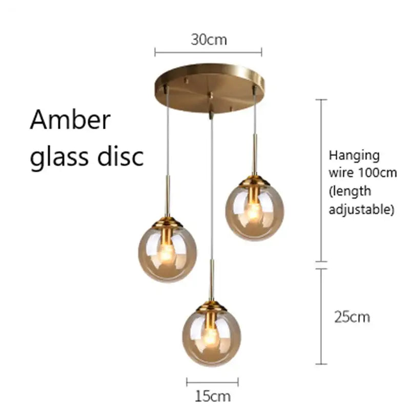 Modern brass and glass pendant lights featuring amber globe glass pendant lights with adjustable hanging wires for kitchen dining room