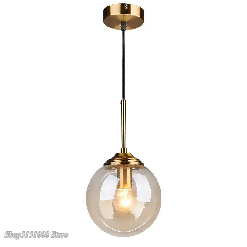 Modern brass and glass pendant light with spherical translucent globe ideal for kitchen and dining room lighting