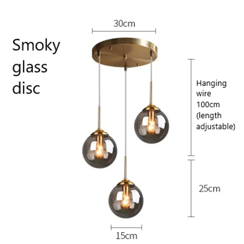 Modern brass and glass pendant lights featuring smoky glass pendant globe shades and metal fixtures for kitchen dining room