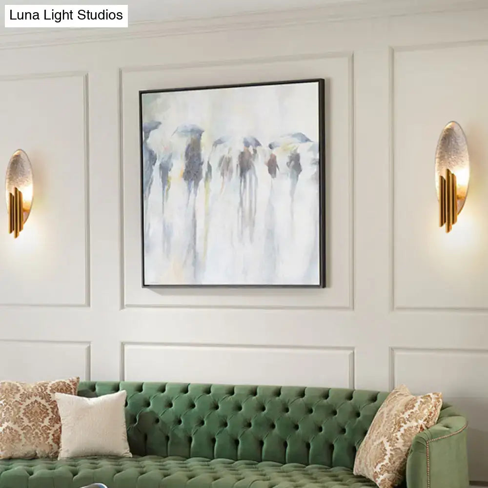 Modern brass and glass wall light sconce with e12 e14 base displayed beside abstract painting with blue yellow brushstrokes