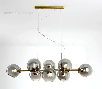 Modern brass pendant lights with seven smoked gray glass globes in a linear design for kitchen and dining room