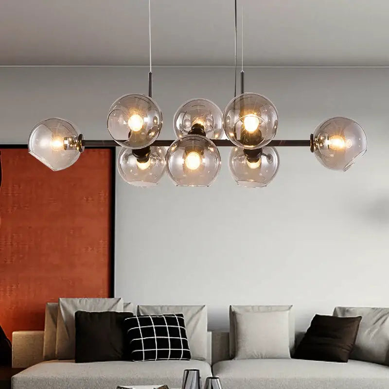 Modern brass and gray glass pendant lights feature glass pendant lights with warm bulbs and sleek black metal frame for kitchen dining