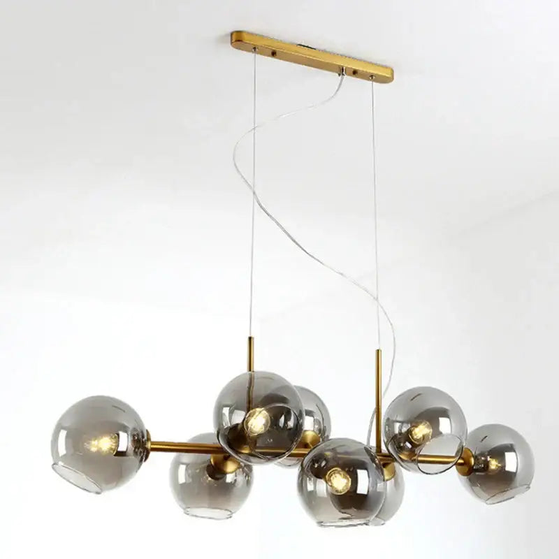 Modern brass pendant lights with spherical bulbs and gray glass pendant shades for kitchen and dining room lighting