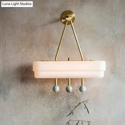 Modern brass and gray sconce light fixture wall lamp with brushed brass frame and frosted glass for dining room wall