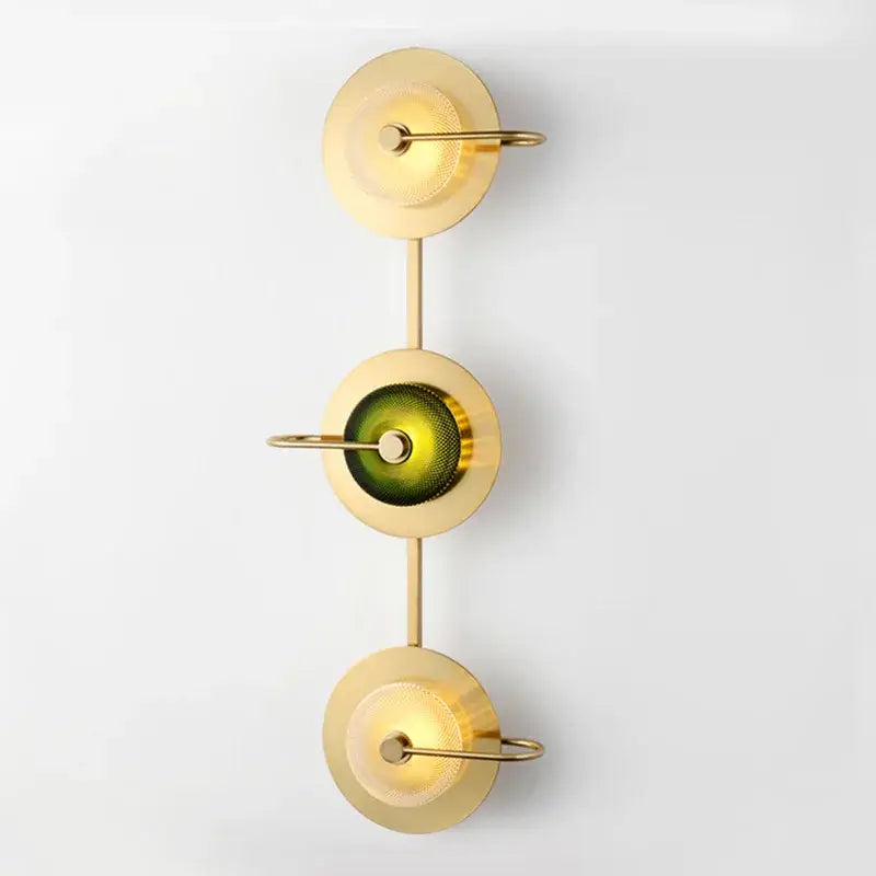 Modern brass and green glass metal wall art lamp with three circular shades and warm ambient lighting for living room