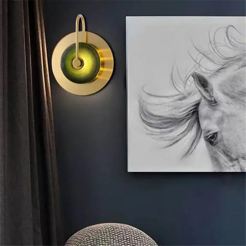 Modern brass and green glass metal wall art lamp featuring a gold-toned circular sconce with textured diffuser