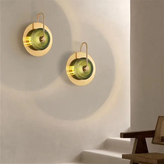 Two elegant brass metal wall art sconces with textured green glass shades for living room lighting