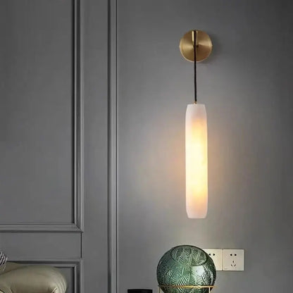 Modern brass and marble wall lamp with frosted glass shade and warm glow for bedroom decorbites cylindrical style