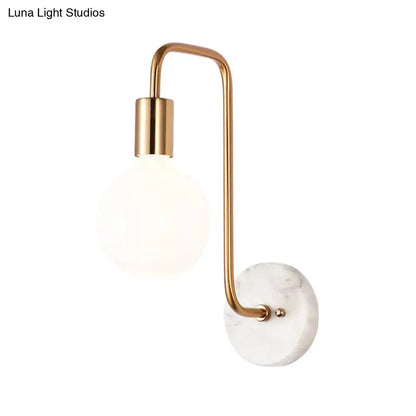 Modern brass and marble wall lamp featuring a white glass sconce with a brass arm and marble base plate for bedroom use