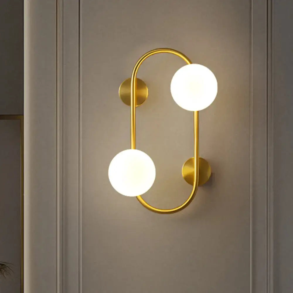 Modern brass and milk glass led wall mount lamp with gold-toned sconce and frosted glass globes for bedroom use