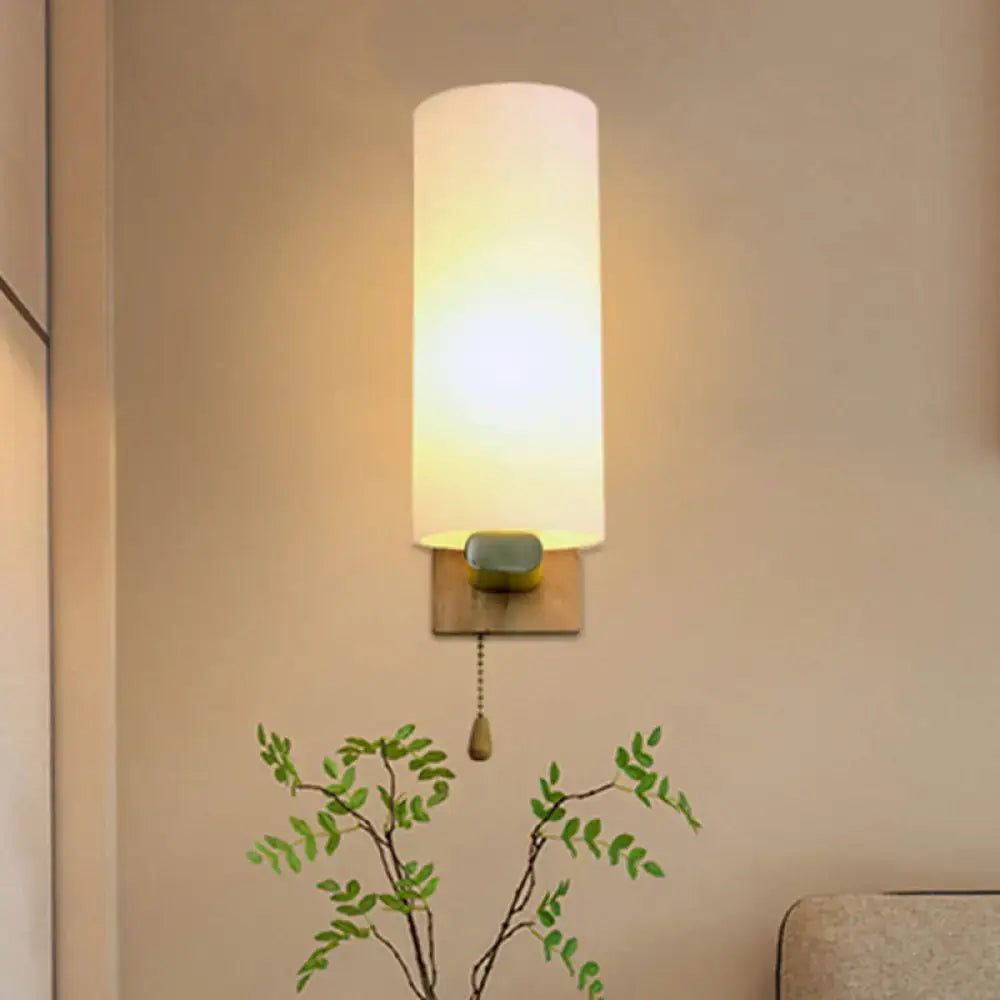 A warm modern brass wall lamp with opal glass shade and brushed base for 220v-240v bedroom use