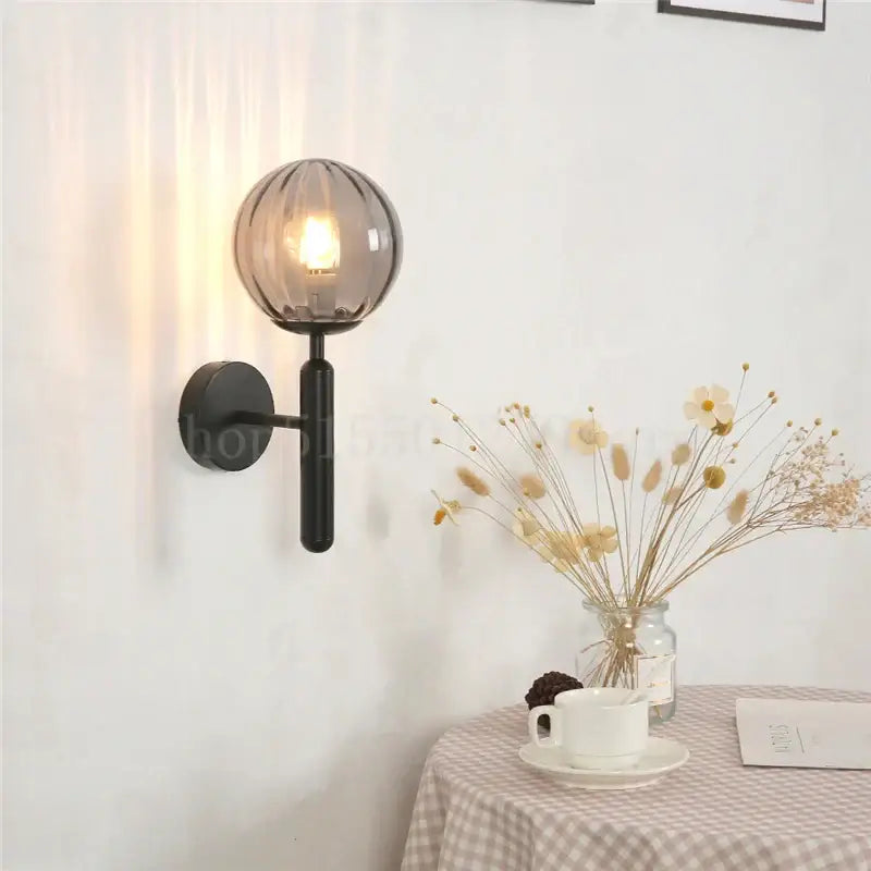 Modern brass wall lamp with sleek black mount and smoky glass globe for living room decorbites blue glass balls
