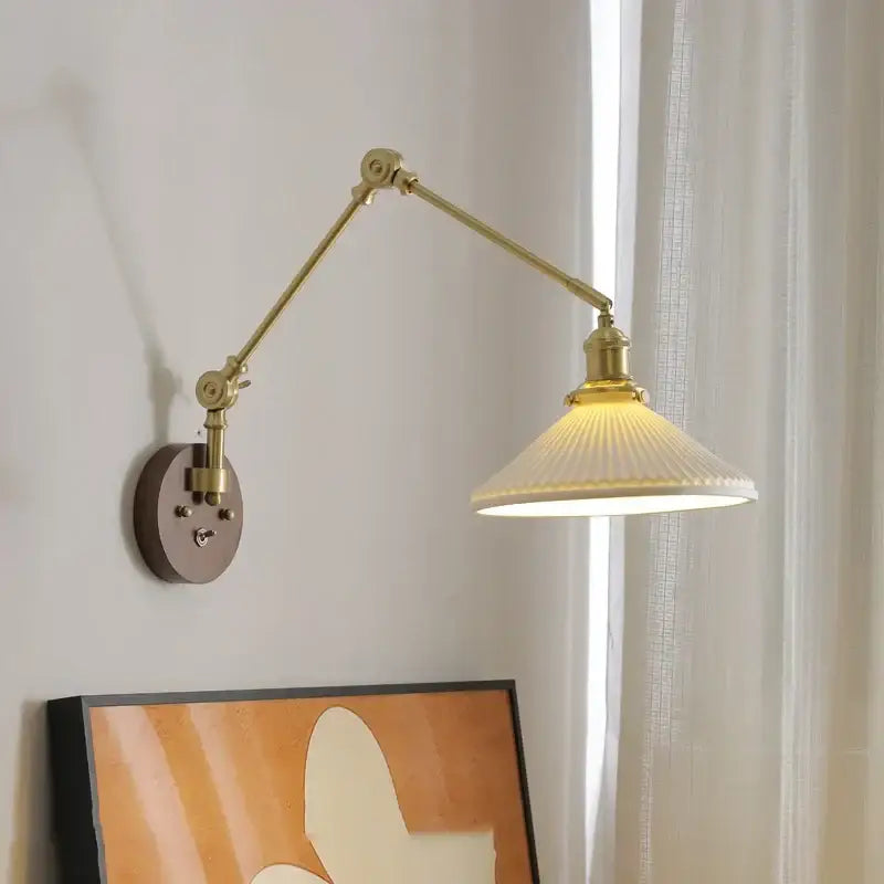 Modern brass and ribbed glass led wall lamp with adjustable brass arm and cream ribbed glass shade for bedroom use