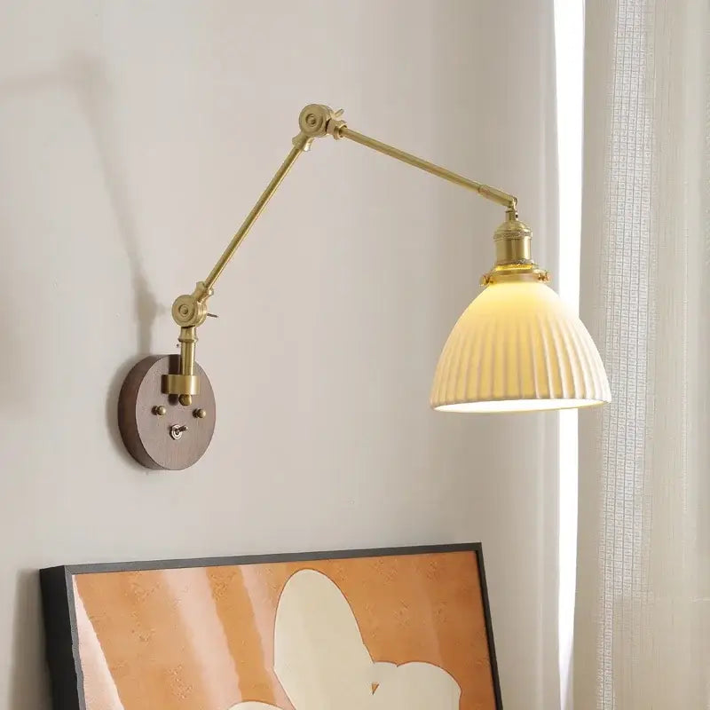 Modern brass and ribbed glass led wall lamp with adjustable brass arm and cream-colored shade for bedroom lighting