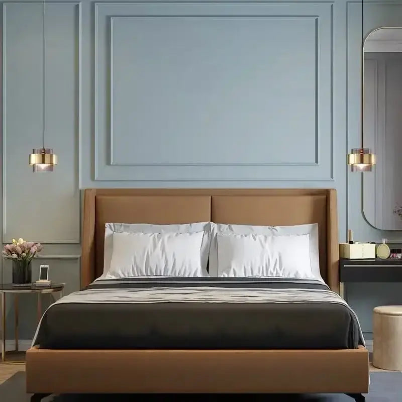 Brown upholstered bed with white pillows featured alongside modern brass and smoked glass pendant light decorbites gold wrought iron