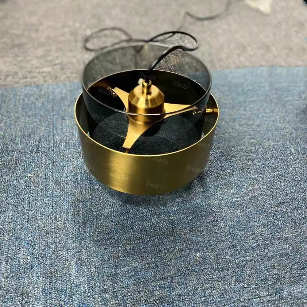 Gold-colored blender blade assembly with three sharp blades featured in modern brass and decorbites gold wrought iron pendant light