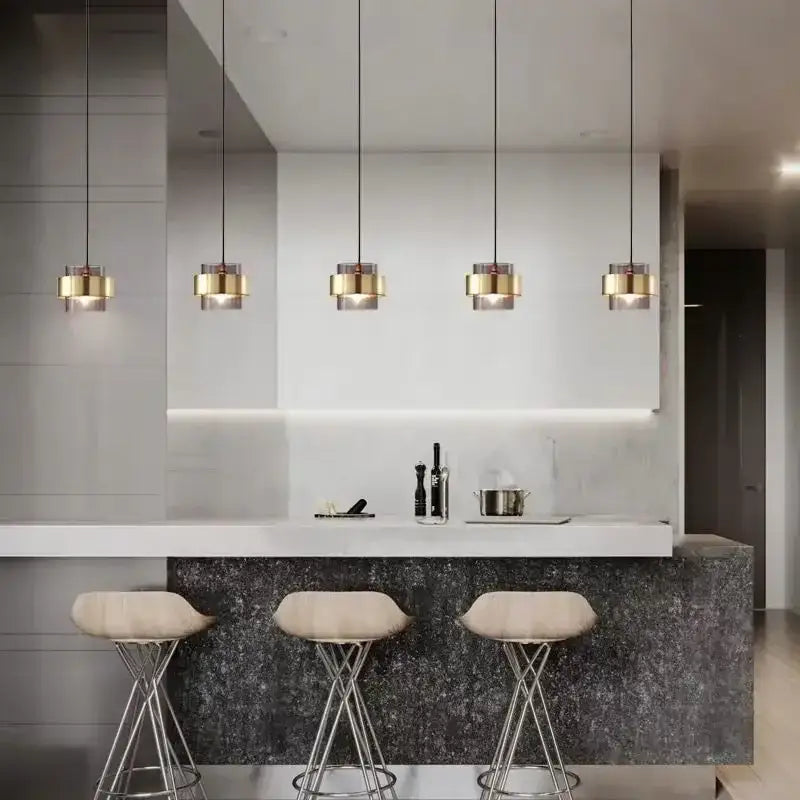 Five modern pendant lights with gold wrought iron cylindrical shades and clear glass accents for dining room decorbites gold wrought