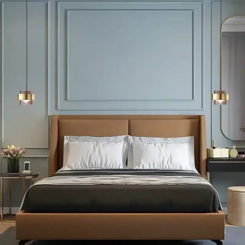A sleek tan upholstered bed with modern design paired with a decorbites gold wrought iron pendant light