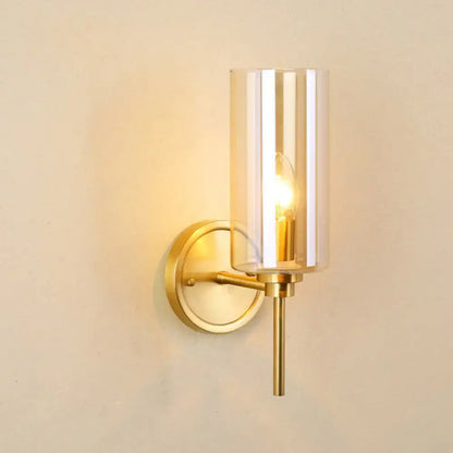 Modern brass and smoked glass wall sconce with gold-toned finish and cylindrical shade featuring e26 bulb base