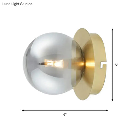 Modern brass wall lamp with smoky glass shade and exposed filament bulb as stylish bedroom light fixture