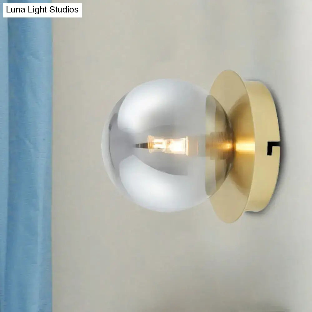 Modern brass wall lamp with a smoky glass shade light fixture featuring a brushed brass base and exposed bulb