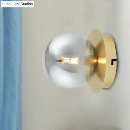 Modern brass wall lamp with a smoky glass shade light fixture featuring a brushed brass base and exposed bulb