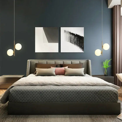 Modern gray upholstered bed with tufted headboard and geometric-patterned duvet beneath smoky gray glass globe pendant light