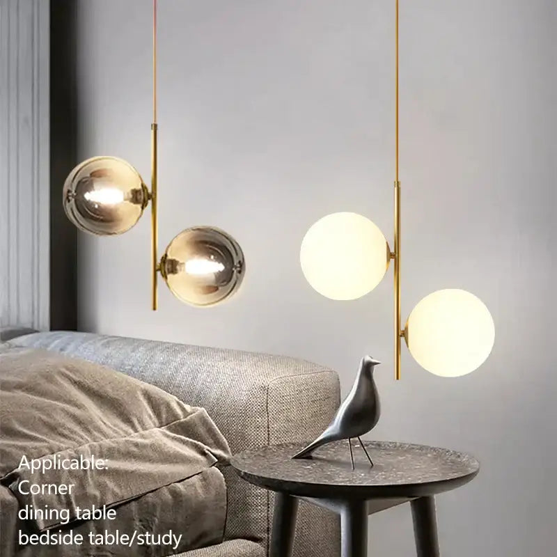 Modern brass pendant light with smoky gray glass globe shades featuring one translucent and two mirrored globes for dining room