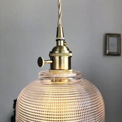 Modern brass pendant light with textured clear glass globe and knob switch for kitchen decorbites clear glass design