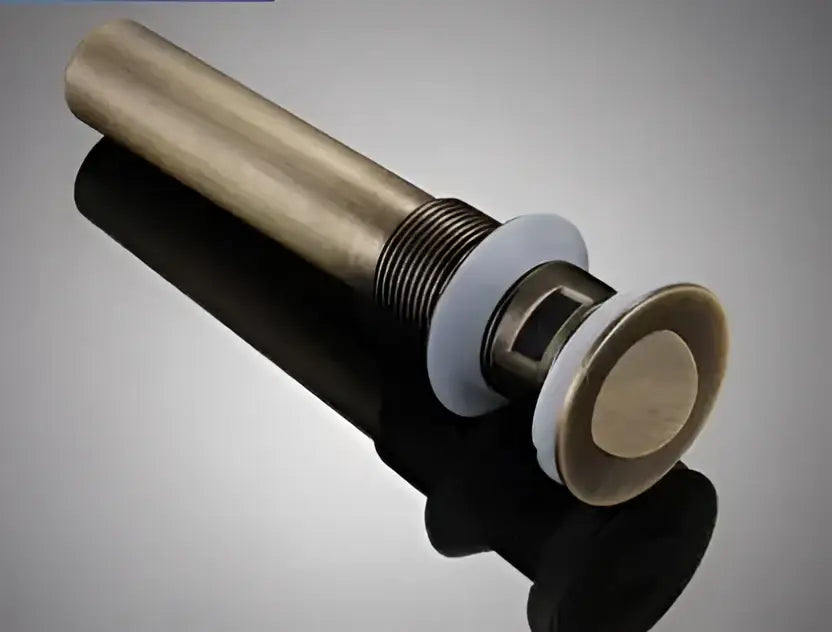 Modern brass and white ceramic basin waste drain stopper with antique brass finish and sleek cylindrical body for bathroom sinks