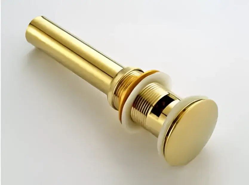 Modern brass and white ceramic basin waste drain with gold-toned metal finish and sleek cylindrical design for bathroom sink
