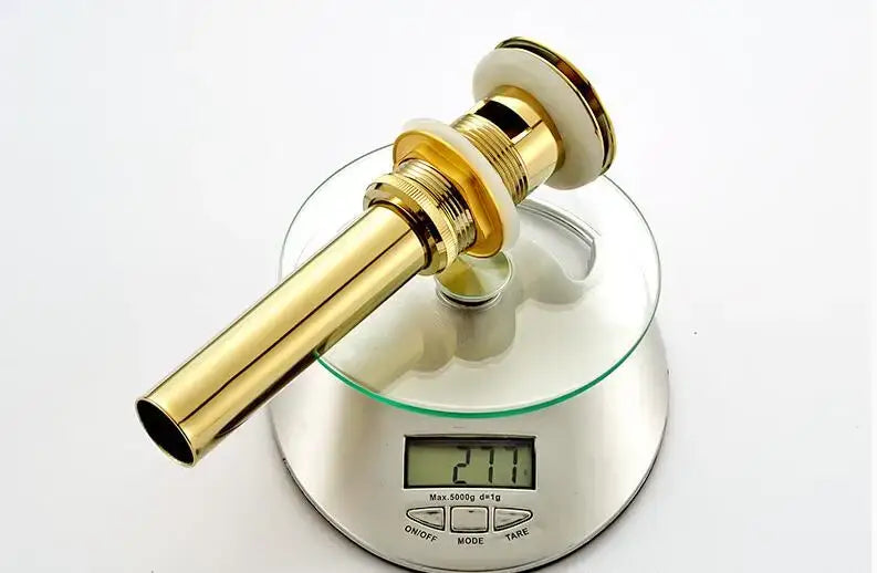 Modern gold-colored brass basin waste drain stopper with sleek cylindrical design and polished finish for bathroom sink