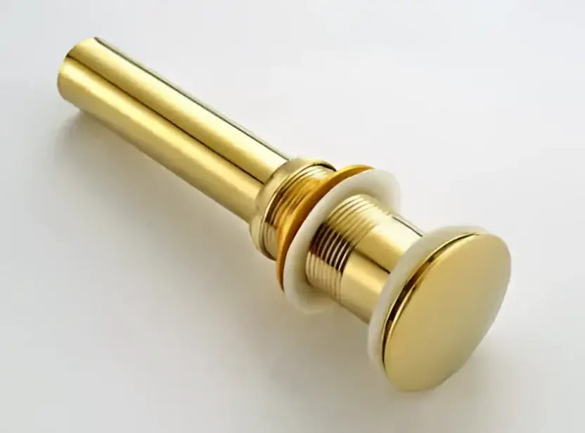Modern brass and white ceramic basin waste drain with a gold-colored polished metallic finish for bathroom sinks