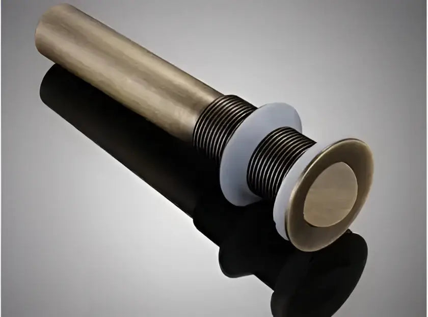 Modern brass and white ceramic basin waste drain with a polished antique brass finish and sleek cylindrical design