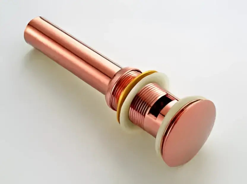 Modern brass and white ceramic basin waste drain with rose gold copper-toned cylindrical bathroom sink stopper