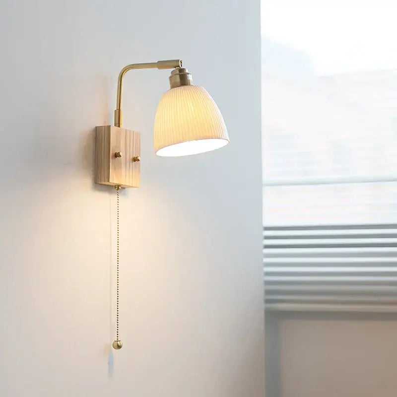 Modern brass and wood ceramic led wall sconce with warm-toned brass and ribbed off-white glass shade for bedroom vanity light