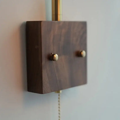 Dark walnut wood wall-mounted led wall lights with brass knobs and matching brass pull chain for bedroom use