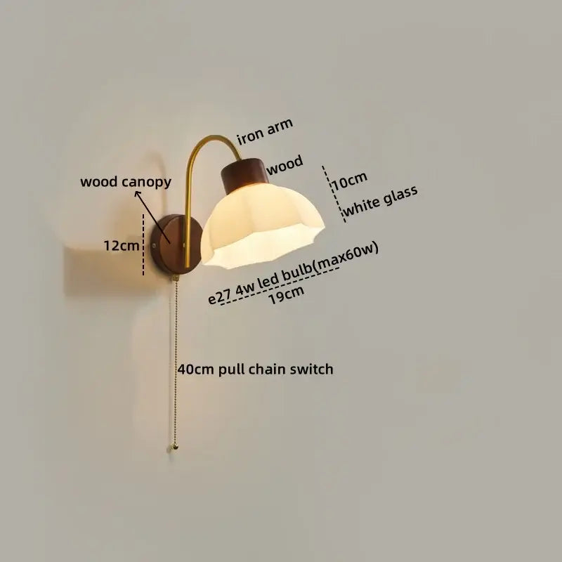 Modern brass and wood led wall sconce pull with warm-toned brass arm, dark wood base, and white glass shade for bedroom decorbites led wall