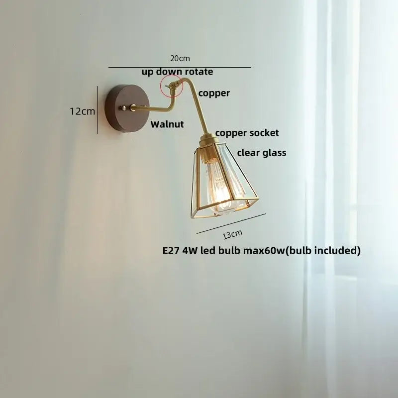 Modern brass and wood wall sconce with copper-finished rotating arm, walnut base, clear glass shade, and amber led decorbites copper glass