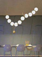 Modern brass artistic necklace chandelier pendant light with white spherical bulbs and a hanging golden sphere for decorbites brass artistic decor