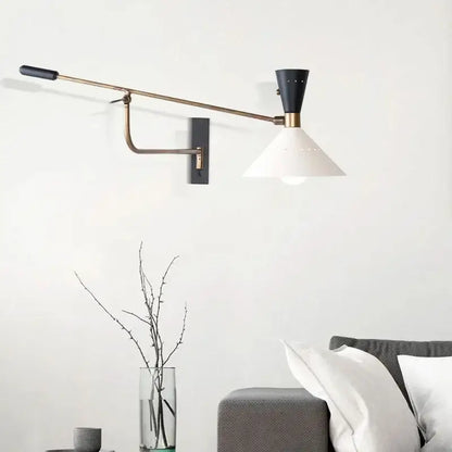 A sleek black and brass decorbites adjustable metal bedroom sconce with a white conical shade for modern decor