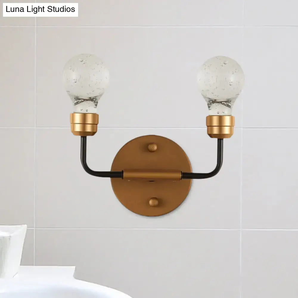 Modern brass and black wall light with two speckled glass bulb shaped sconce globes for bedroom use