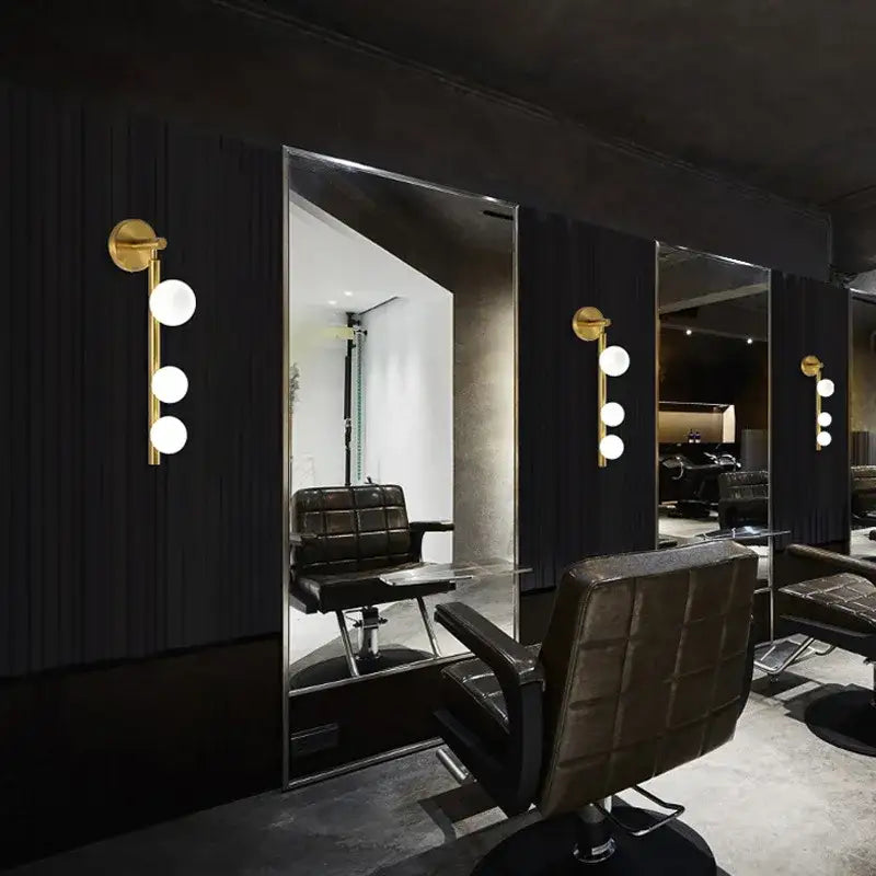 Modern brass and black frosted glass wall lamp with chrome base paired with black leather tufted barber chair decorbites elegant mirror headlight