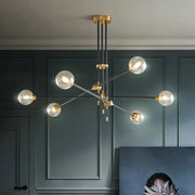 Modern brass and black metal geometric glass ball chandelier with clear glass globe bulbs for dining room decorbites geometric glass