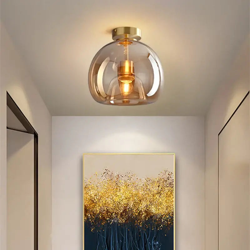 Modern brass and black glass ball LED ceiling light featuring a smoked glass globe and gold-toned metal accents decorbites glass ball