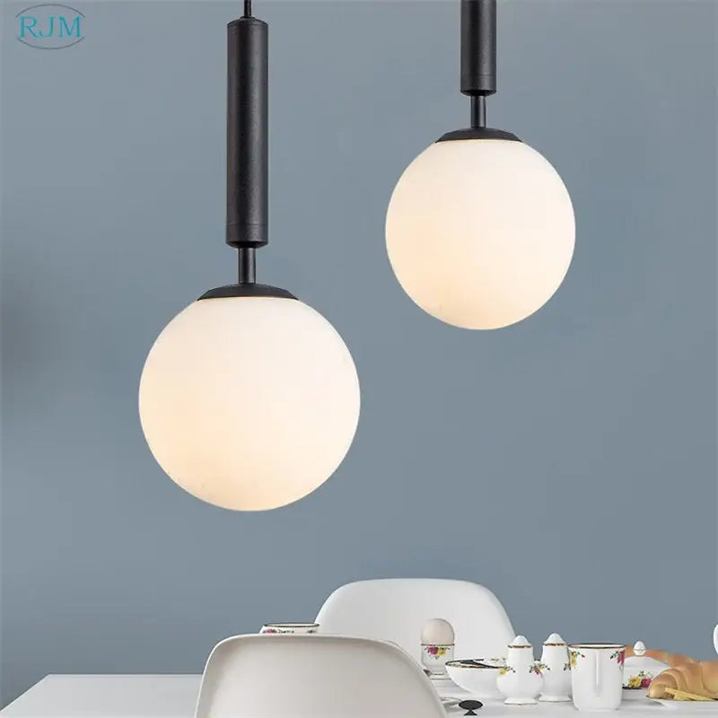 Modern brass and black glass ball led pendant light with black cylindrical fixtures and frosted white glass shades
