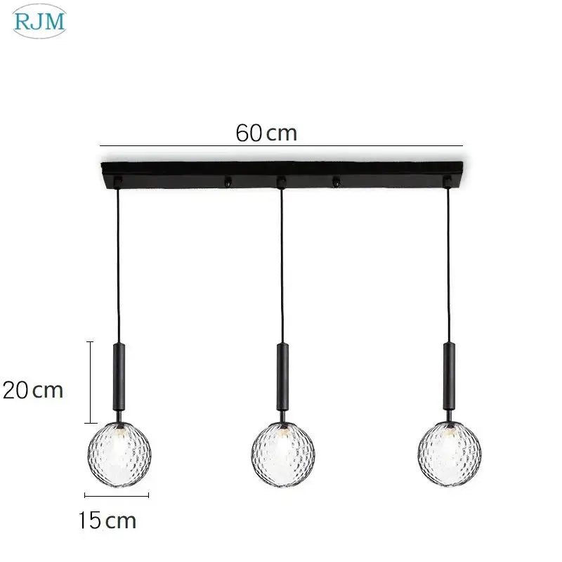 Black metal pendant light with three textured decorbites glass ball led globes suspended by black cords for dining room decor